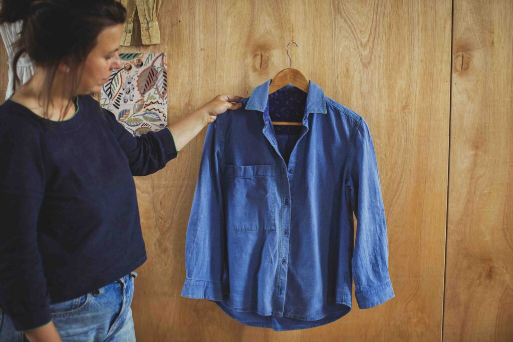 Shirt making weekend in West Wales. Camille holds up a blue shirt.